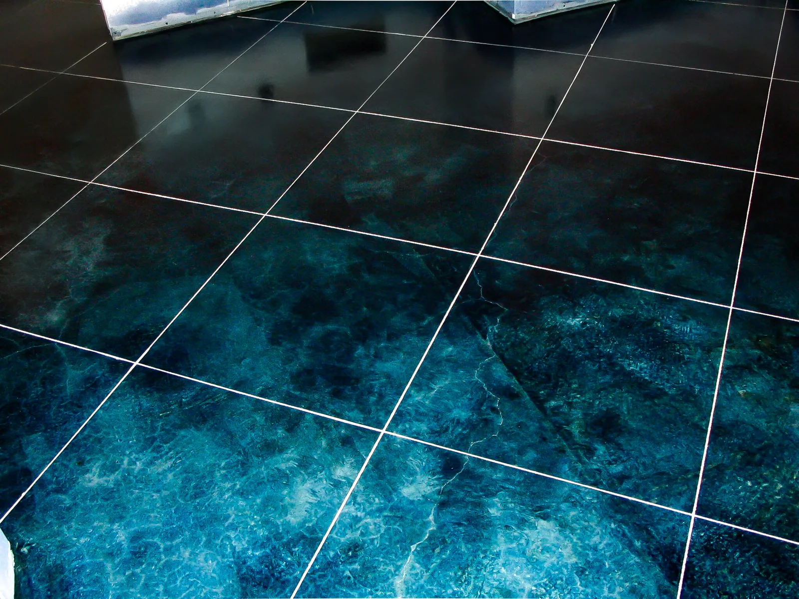 Acid-stained concrete floor sealed to a gloss, with a sawcut grid pattern