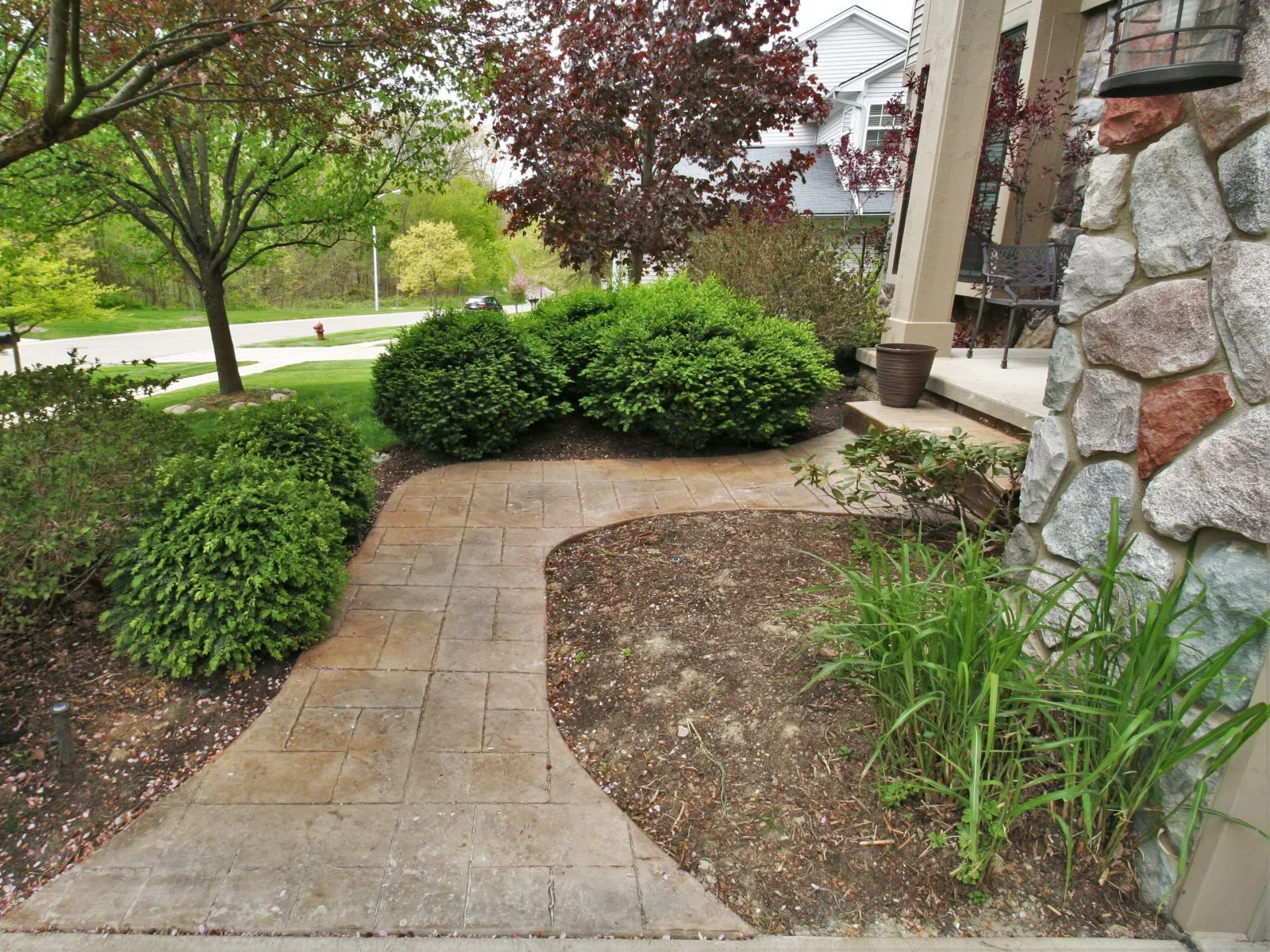 Stamped concrete front walkway curving through landscaping to a home's front entry