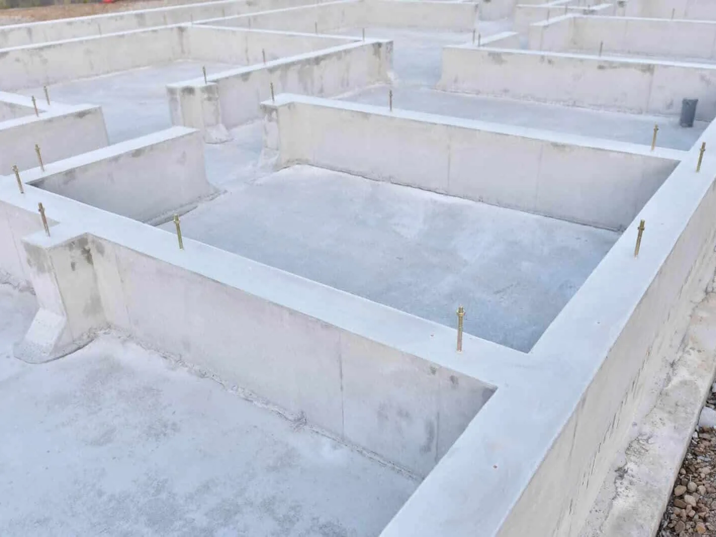 Finished poured concrete stem-wall foundation with the forms stripped and anchor bolts set
