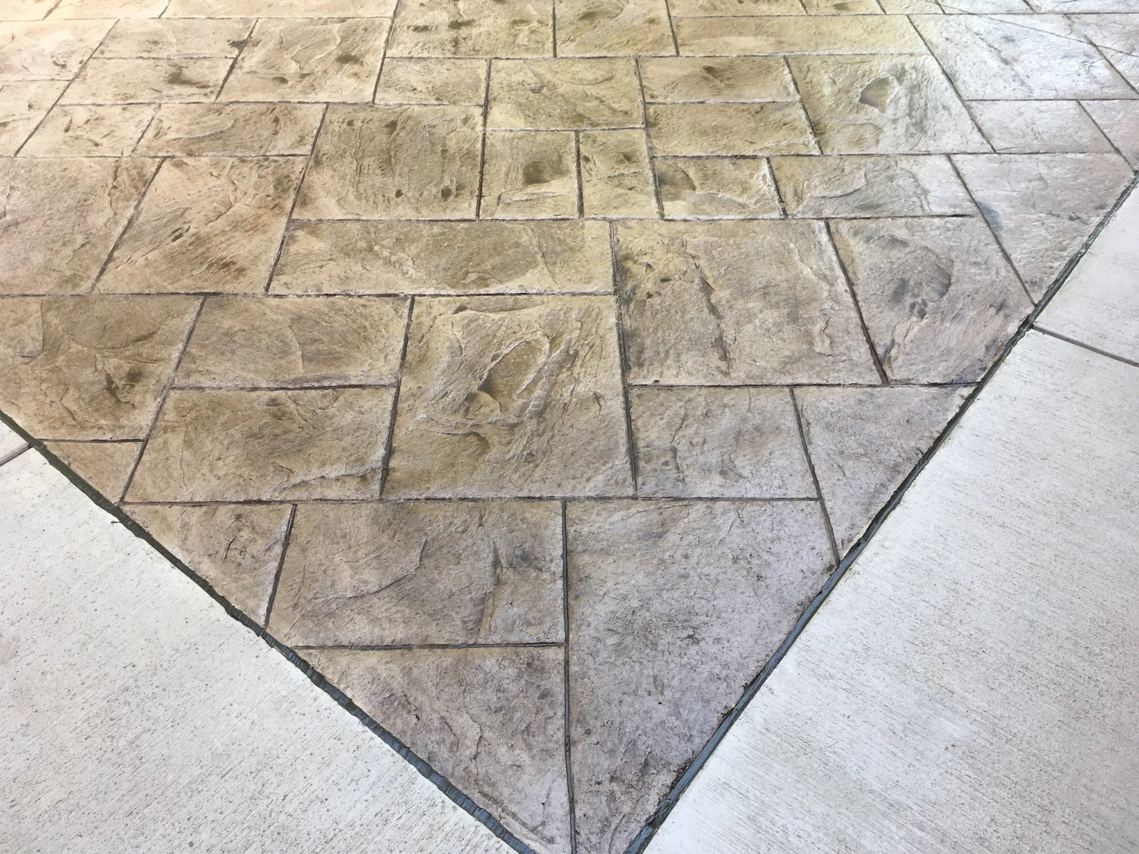 Finished ashlar-slate stamped concrete panel bordered by plain broom-finish concrete